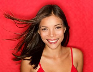 12357146 - beauty woman happy. beautiful fresh multiracial girl smiling fresh and natural on red background.