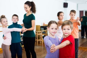 Group of children dancing pair dance in dance hall